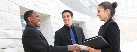 A man in suit shaking hands with another person.