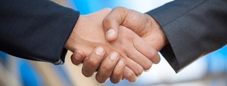 Two people shaking hands over a blue background