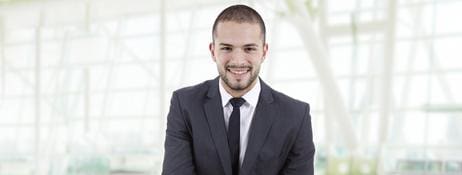 A man in suit and tie smiling for the camera.